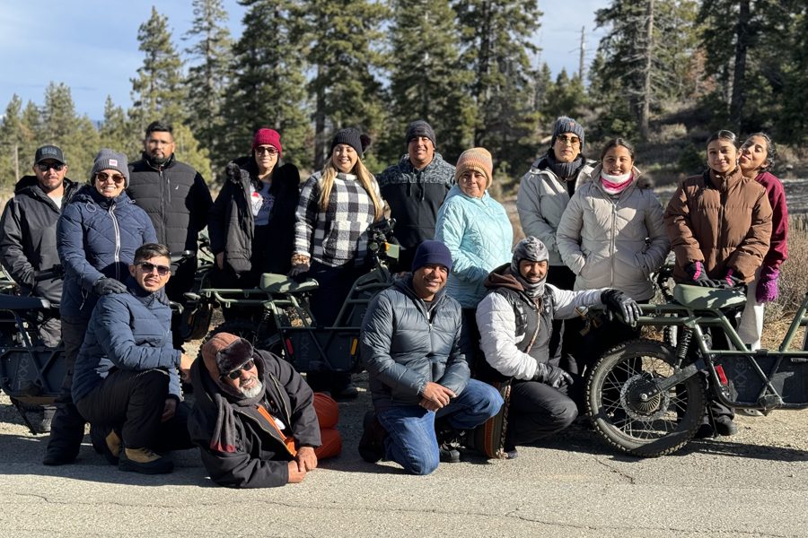 Group of guests in jackets posing with electric dirt bikes in South Lake Tahoe