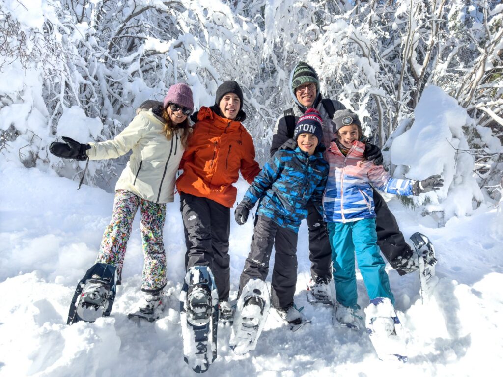 Family of five on a snowshoe tour in fresh snow near Lake Tahoe